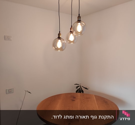 שלוש נורות תלויות מהתקרה בחדר